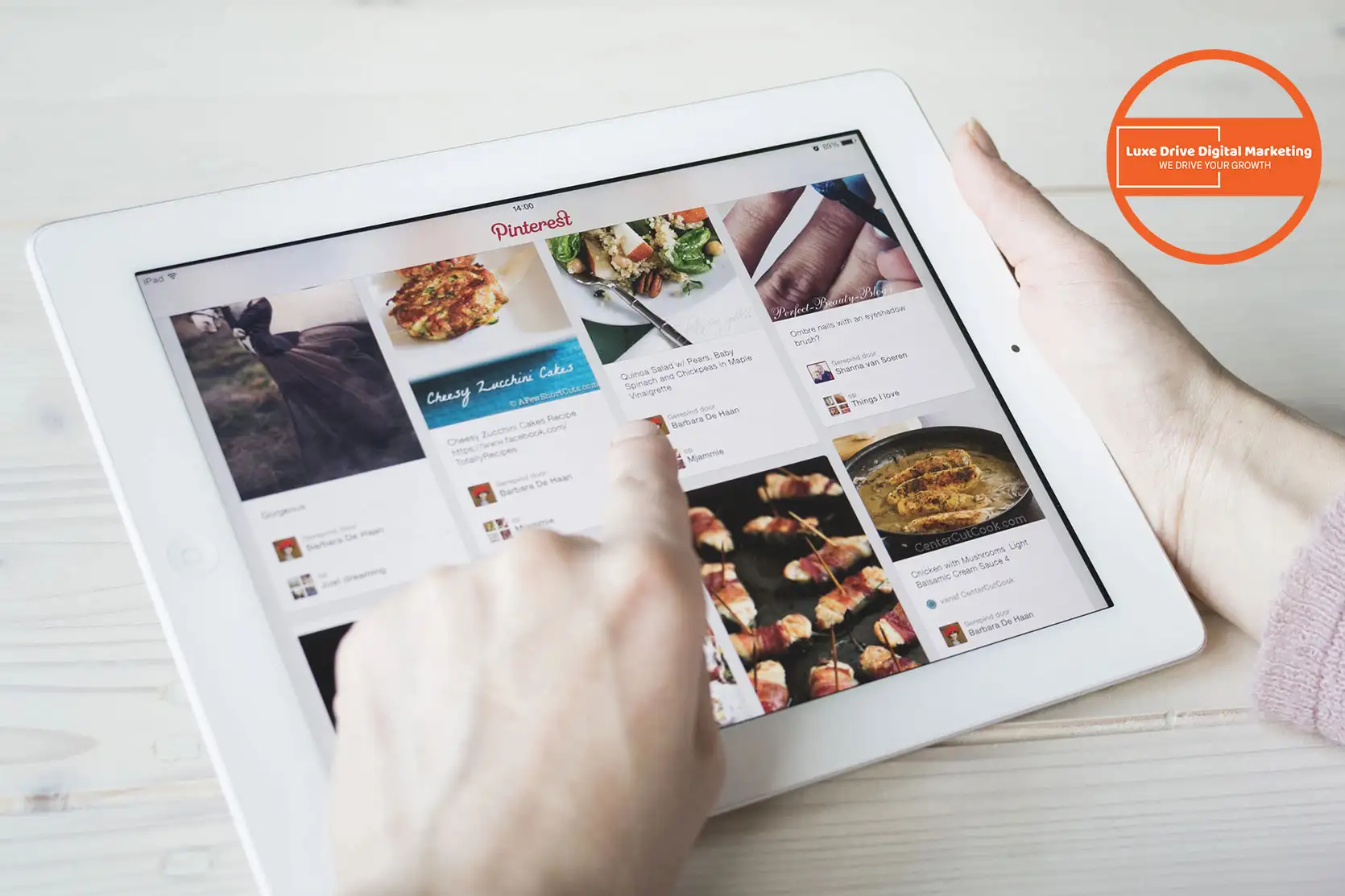 Luxe Drive Digital Marketing America's Top Marketing Agency A person uses a white tablet displaying a Pinterest page filled with various images, while the Luxe Drive Digital Marketing logo is prominently visible in the upper right corner. Luxe Drive Digital Marketing We Drive Your Growth