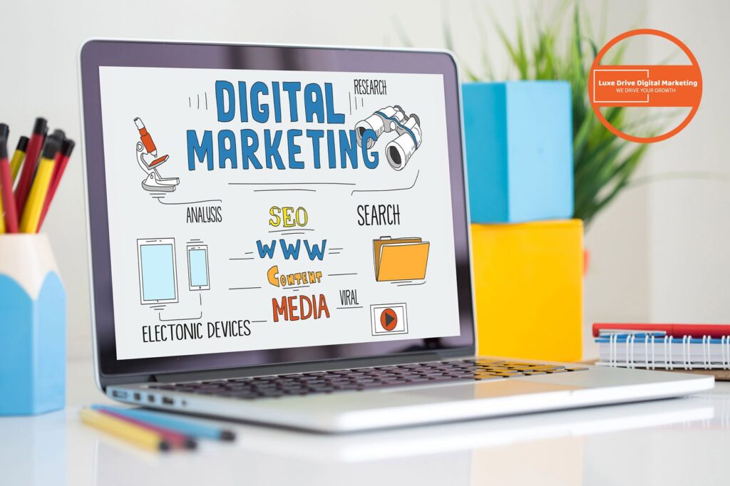 Luxe Drive Digital Marketing America's Top Marketing Agency A laptop screen displays a digital marketing concept with illustrations and keywords like SEO, content, and search. Office supplies are visible in the background. Luxe Drive Digital Marketing We Drive Your Growth