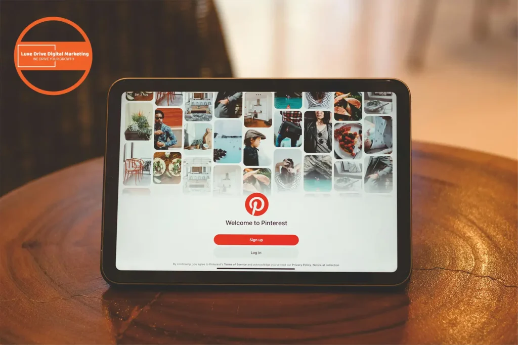 Luxe Drive Digital Marketing America's Top Marketing Agency Tablet displaying Pinterest login screen, featuring a grid of various images. Luxe Drive Digital Marketing We Drive Your Growth